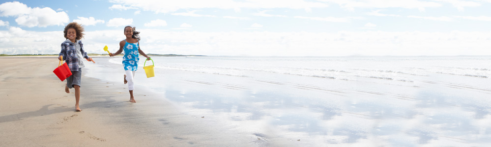 Two children running on beach shore